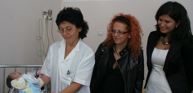 Доц. Анелия Беува, ръководител на клиниката по нефрология и хемодиализа, показва как мониторът прави безкръвно изследване на малкия Дениз. Вдясно от нея -  Милена от „Тройка на разсъмване” и Светлана Маеркова, ръководител „Картови продукти” на СИБАНК